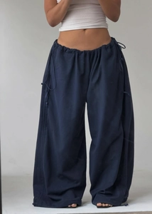Detail of navy wide-leg trousers with adjustable drawstrings and elastic waist design
