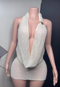 Detail of white knit mini dress featuring deep V-neck and intricate mesh weave texture