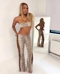 Detailansicht von Schlangenmuster-Bandeau-Top und Schlaghose mit seitlichen Fransen
