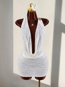 Close-up of intricate floral white lace fabric on a sexy halter neck V-neck dress