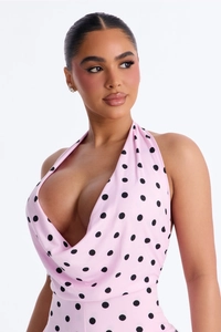 Detail of pink polka dot halter neck dress featuring deep V neckline and fabric texture