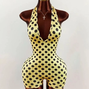 Pagliaccetto giallo a pois neri con scollo a V profondo mostrato su un manichino da esposizione