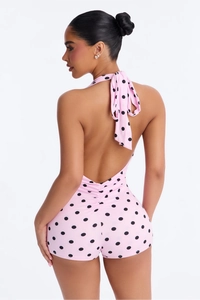 Detailed back view of pink polka dot halter romper with ruched waist and open back design