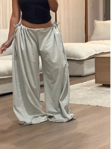 Detail of adjustable drawstring waistband and wide-leg hem on gray lounge pants