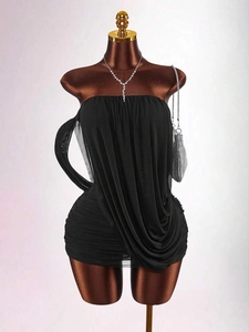 Detailed view of black tube dress with pleated mesh fabric and silver chain bag