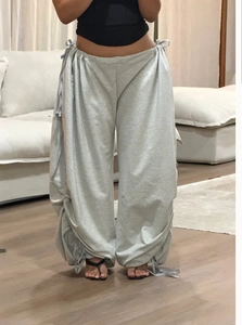 Detail view of light grey wide-leg lounge pants with adjustable drawstring waist and hem