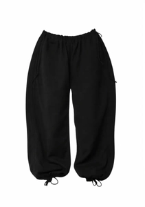 Detail of adjustable drawstring waistband and cuff on black wide-leg joggers