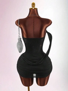 Sleeveless black lace patchwork ruched mini dress displayed on a dress form with a silver bag
