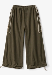 Detail of olive green wide-leg trousers featuring white drawstring and textured cotton fabric