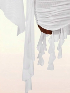 Detail des weißen Netzkleids mit eleganten Faltenrüschen und transparenten Stofflagen