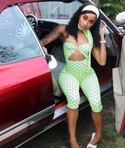 Makroansicht des neongrünen Polka-Dot-Bodysuits mit passendem Stirnband und Halter-Ausschnitt