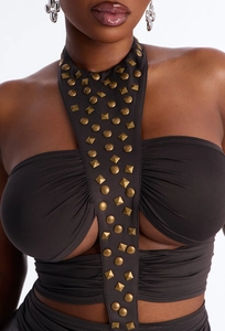Dettaglio delle borchie in metallo e trama a pieghe su questo top sexy con scollo