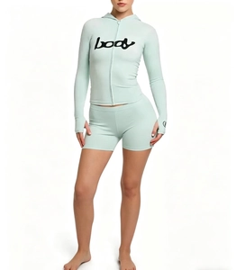 Detail of mint green athletic set featuring hooded zip jacket with body print and shorts