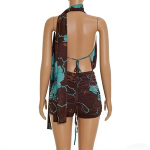 Detail of deep V-neck halter jumpsuit with blue floral print and cross-back straps