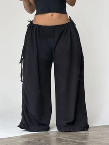 Black loose-fit wide-leg trousers with adjustable drawstring waist and side cords