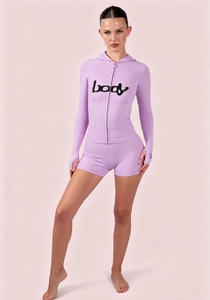 Close-up of purple high-stretch two-piece sportswear with hoodie and body text print