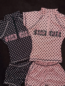 Detail of polka dot swimsuits with star girl print and half-zip short sleeve tops