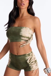 Close-up detail of green tie-dye fabric textures and stylish side tassel fringes on shorts