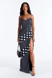 Detail eines Seidensatin-Maxikleids mit schwarz-weißem Polka-Dot-Patchwork und Seitenschlitz