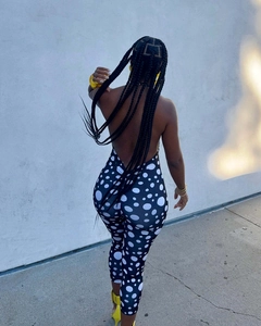 Detail of a halter backless jumpsuit with large white polka dots on a black fabric