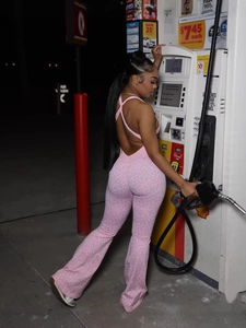 Pink leopard print backless jumpsuit with flare leg and crisscross straps on a model