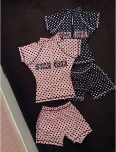 Detail of two kids polka dot swimsuit sets featuring Star Girl print and zip-up tops