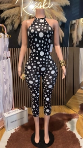 Close-up of stylish black and white polka dot halter neck jumpsuit in boutique setting