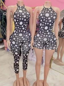 Detail view of black and white polka dot halter neck jumpsuits in long and short styles