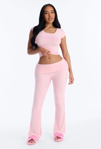 Detail of pink crop top with Wifey print and matching flared pants on a model