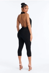 Detail view of the halter neck tie and open back design on this black slim jumpsuit