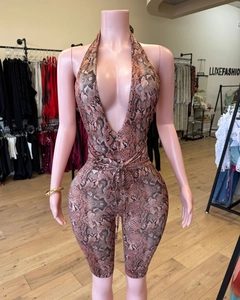 Close-up of snake skin print romper featuring deep V-neck and halter tie-up design
