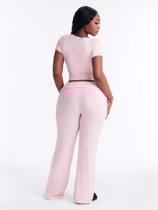Women's pink two-piece crop top and flared pants set with Wifey print on back