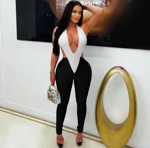 Detail of high-contrast black and white jumpsuit featuring a plunging deep V-neck halter