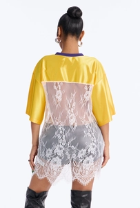 Detail of yellow satin shirt back with white floral lace splicing and eyelash lace hem