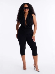 Chic black deep V-neck halter jumpsuit with gold stud accents and a sleek cropped fit