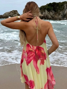 Outdoor back view of backless floral dress with neck tie on beach background