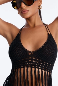 Close-up of black crochet halter top featuring intricate knit patterns and long tassels