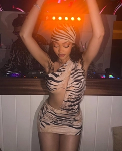 Detail of tiger print dress featuring one-shoulder cutout design and matching headscarf