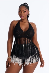 Close-up of black crochet halter top with long fringe tassels and intricate knit texture