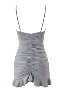 Detailed close-up of grey ruched mini dress with thin straps and ruffle hem design