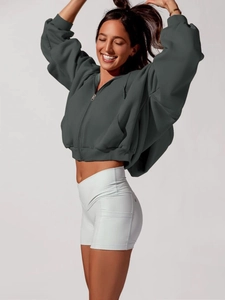 Detail of dark grey zip-up hoodie with ribbed cuffs and white high-waist sports shorts
