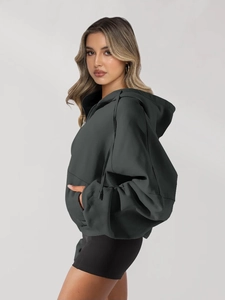 Detail of dark charcoal zip-up hoodie featuring thick cotton fabric and oversized pockets