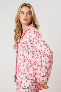 Detail view of pink Christmas pajama set with candy cane and snowflake pattern and piping