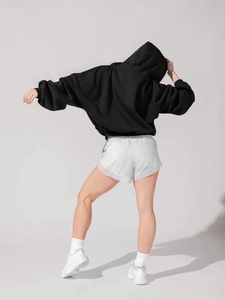 Rear view of oversize black hooded sweatshirt and white double-layer athletic shorts