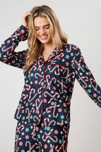Close-up of navy Christmas pajama set with candy cane print and red contrast piping
