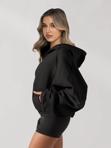 Side view of oversized black zip-up hoodie featuring a drawstring hood and side pockets