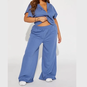 Detail of high-waisted blue wide-leg lounge pants and zip-up collar of a soft tracksuit