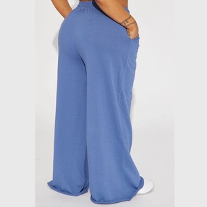 Rear view of blue high-waisted wide-leg yoga pants showing drape and raw hem detail