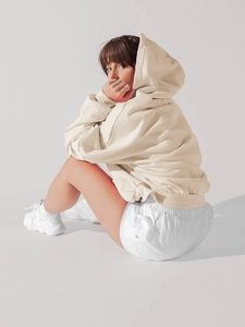 Detail of light beige oversized hoodie with drop shoulder design and cotton texture