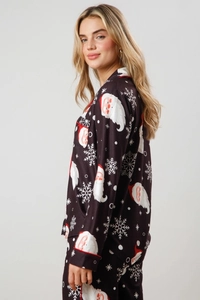 Close-up of Christmas pajamas featuring Santa and snowflake prints with red piping detail